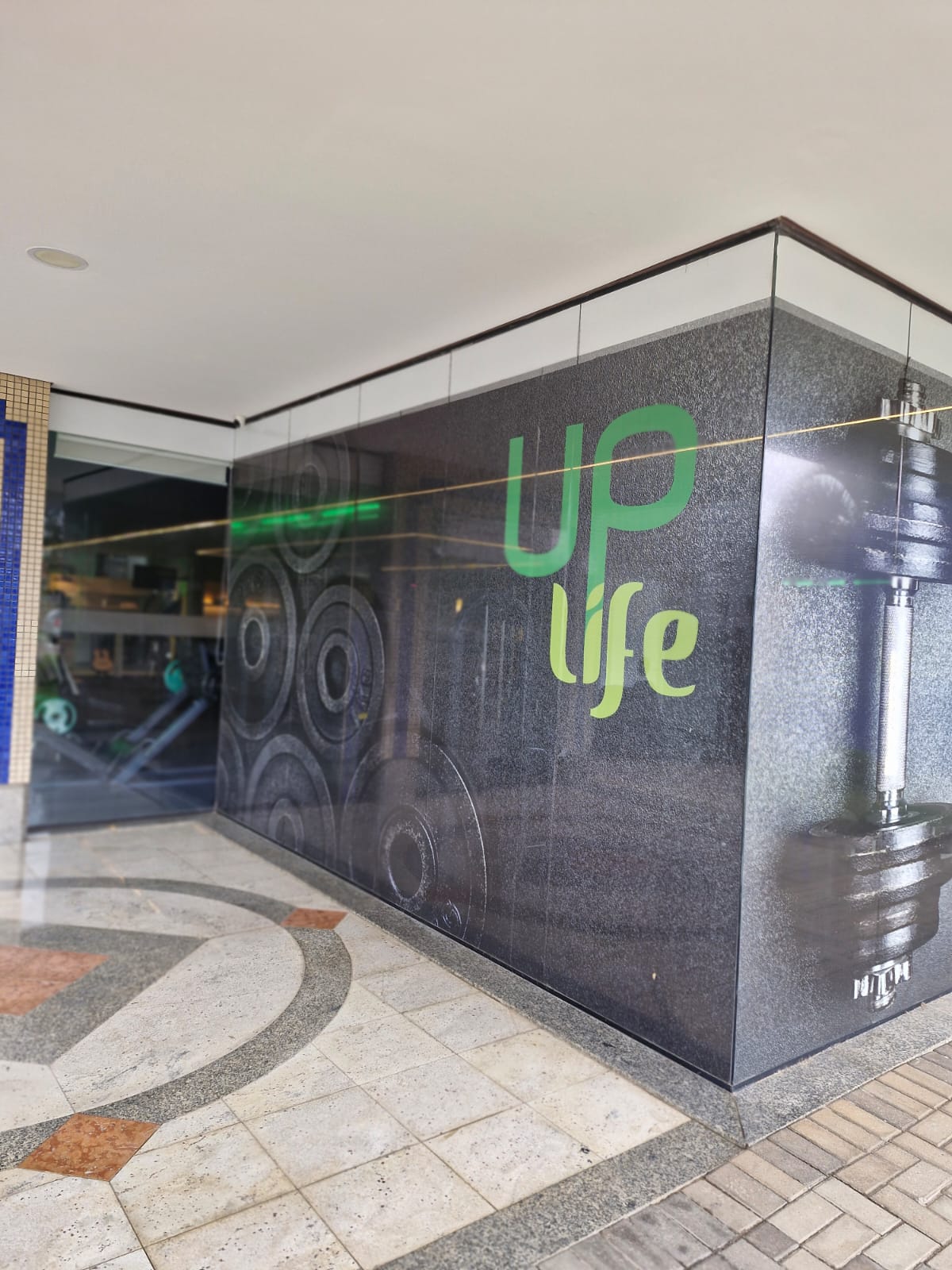 Fachada do Uplife Studio, com a logo iluminada, em Santa Felicidade