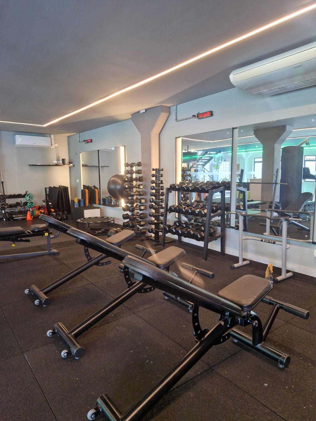 Área de musculação do Uplife Studio, com anilhas e bancos de treino